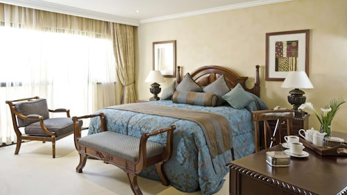 Discover the soul of Kigali in a place where elegance, culture, and comfort intertwine. Tucked just minutes from the city's lively centre, Kigali Serena Hotel is your gateway to Rwanda’s vibrant capital—offering a peaceful retreat with effortless access to top attractions.
Inside, sophistication abounds. Choose from beautifully appointed Standard, Deluxe and Superior Rooms, or indulge in the space and exclusivity of a suite. The crown jewel is the expansive Presidential Suite—spanning 300 square metres with its own private floor, Jacuzzi bathroom, private dining room, and stylish lounge. Pan-African design flourishes throughout, with bold fabrics, handcrafted furnishings, and all the 5-star amenities you’d expect—high-speed Wi-Fi, minibars and 24-hour room service.
Whether relaxing by the tropical pool, unwinding at the Moroccan-inspired Maisha Spa, or enjoying live music and global cuisine at Sokoni Restaurant, your stay is rich in unforgettable experiences. Venture out to the nearby Kigali Genocide Memorial, Inema Art Center, or the vibrant Nyamirambo Women’s Center for a deeper connection to Rwanda’s heart and soul.
INSIDER’S TIP: Don’t miss a sunrise dip in the plunge pool—followed by a fresh juice from the self-service bar—it’s the perfect way to start your day in Kigali.
