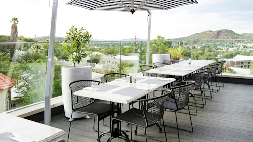 Discover the perfect balance of modern sophistication and old-world charm at The Weinberg, an urban oasis set in the vibrant heart of Namibia’s capital. Just minutes away from the city’s iconic landmarks – like Christ Church and the National Museum – the hotel is ideally positioned for both exploration and relaxation.

This boutique property offers a variety of stylish accommodations, from standard rooms to spacious two-bedroomed Terrace Suites. Each suite boasts en-suite bathrooms, air-conditioning, and private balconies. The estate also features fine dining, a luxurious day spa, and state-of-the-art business facilities.

Wind down after a day of sightseeing with a glass of local wine while taking in panoramic views of the valley. Explore Windhoek’s historical sites or indulge in activities like shopping and sampling local delicacies, all just steps from your door.

INSIDER’S TIP:  For a truly unforgettable evening, head to the terrace at sunset. With a glass of fine South African wine in hand, watch the valley light up in hues of gold and amber. Then, retreat to your suite’s private balcony for a starlit dinner, accompanied by the twinkling city lights below. 