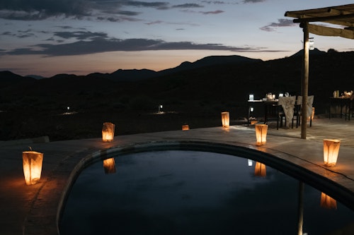 The Huab River Valley lies in one of the best wilderness areas in Namibia, offering endless vistas of plains, valleys and mountains. Wilderness Damaraland Camp is run in partnership with the Torra Conservancy and visits to the local farmstead reveal the fruits of this very positive relationship. 

Each of the ten spacious en-suite, adobe-style thatched accommodations (including a family unit) has a large private viewing deck. New technology and ancient knowledge makes for an ultra-light footprint; nature drives and guided walks offer sights of desert-adapted wildlife, ancient rock-art and striking geological formations. Astonishing night skies round out each day’s experiences. 

Insider’s Tip: Meet members of the local village on a community visit and discover the inspiring story of how Wilderness Damaraland Camp came to be. 


