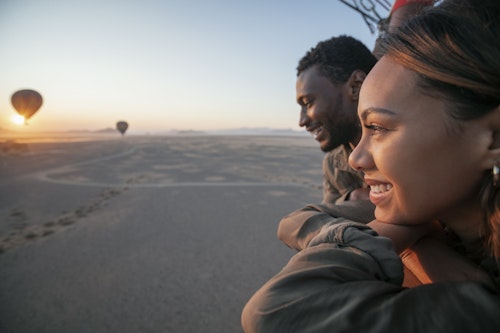 Take to the skies on a spectacular balloon flight over mesmerising Sossusvlei in the Namib Sand Sea, one of the oldest deserts on earth. As the sun rises, you'll lift off and drift gracefully over the endless vistas of towering dunes and mountains, capturing the desert's ancient beauty from a unique perspective. 

Experience the magic of the desert for approximately one hour, with the shifting shadows and lights creating an unforgettable spectacle below. Upon landing, indulge in an "Out of Africa" - style champagne breakfast set in the heart of the desert. Enjoy a decadent feast and exchange stories with your pilot in these stunning surroundings.

After breakfast, a scenic nature drive will take you back to your starting point, allowing you to soak in the splendour of Sossusvlei one last time. This enchanting adventure promises memories that will last a lifetime, leaving you floating on air long after your flight is over.