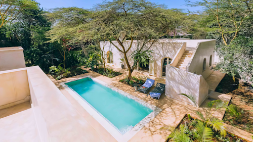 Unwind at Manzili House, a tranquil retreat, nestled in Nairobi's serene suburb of Karen. Inspired by the Swahili architecture of Lamu, this intimate haven exudes charm and sophistication. Each meticulously designed room features a private veranda and en-suite bathroom, for complete comfort and privacy.

Relax by the lush courtyard pool or head up to the shaded roof terrace for picturesque sundowners. With a cosy lounge overlooking the courtyard and a fully equipped kitchen, Manzili House offers exclusivity and serenity for families or groups of up to eight guests. 

Enjoy a delightful breakfast each morning to start your day right. Explore nearby attractions such as the Karen Blixen Museum or Nairobi National Park, then return to Manzili House to unwind in your own private haven.

Insider's Tip: Don't miss the chance to explore the unique blend of culture and nature in Karen, from historical landmarks to wildlife encounters.
