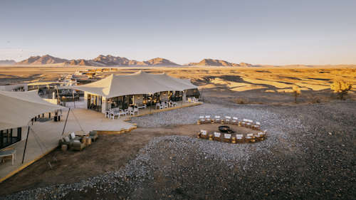 Wilderness Kulala Desert Lodge’s location at the foot of the majestic Sossusvlei dunes allows for stunning views in every direction, while its private entrance to the Namib Naukluft National Park makes it the closest location to Sossusvlei. The camp is ideal for self-drives and groups.

Twenty-one thatched and canvas tents (including two family units), each built on raised wooden platforms make for airy, comfortable accommodation, with a rooftop area for sleep-outs under the stars. Afternoons around the pool provide relief from the heat, while the wraparound veranda at the main area overlooks a waterhole, and private tours of the dunes provide the ultimate Sossusvlei experience.

Insider's Tip: Try your hand at desert photography – whether capturing the red colour of the dunes in the early morning light or the otherworldly tree skeletons standing starkly across the floor of Dead Vlei.